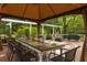 Outdoor dining area under a gazebo with a long table and seating, with views of the backyard and welcome pergola at 540 Shale Ct, Alpharetta, GA 30022
