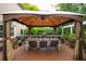 Outdoor dining area on the deck with a large table, seating for eight, a ceiling fan, and a gazebo for shade at 540 Shale Ct, Alpharetta, GA 30022