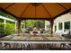 Covered outdoor dining area with a long table set for a meal, and a view of the grill, pergola, and backyard at 540 Shale Ct, Alpharetta, GA 30022