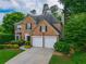 Charming brick home with a two-car garage, manicured landscaping, and mature trees at 540 Shale Ct, Alpharetta, GA 30022
