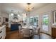 Bright kitchen featuring white cabinets, a blue island, stainless steel appliances, and a round breakfast table near the patio doors at 540 Shale Ct, Alpharetta, GA 30022
