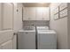 Laundry room featuring a washing machine, dryer, and built-in cabinets for storage at 540 Shale Ct, Alpharetta, GA 30022