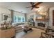 Bright living room features a stone fireplace, large windows, stylish furniture, and views of the backyard at 540 Shale Ct, Alpharetta, GA 30022