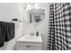 Bathroom with an oval mirror, white sink, and black-and-white shower curtain at 1192 Arlington Sw Ave, Atlanta, GA 30310
