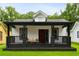 Charming home with a cozy front porch, black trim, and a freshly manicured lawn at 1192 Arlington Sw Ave, Atlanta, GA 30310
