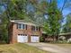 This brick home features a well-maintained lawn, a two-car garage and mature trees for added curb appeal at 2516 Cherry Hill Ln, Atlanta, GA 30360