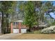 Charming brick home featuring a two-car garage and a beautifully landscaped front yard with mature trees at 2516 Cherry Hill Ln, Atlanta, GA 30360
