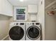 Bright laundry room featuring side-by-side, front-load washer and dryer units, and overhead storage at 2516 Cherry Hill Ln, Atlanta, GA 30360