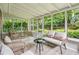 Inviting sunroom with wicker furniture, neutral cushions, and views of the green landscape at 2516 Cherry Hill Ln, Atlanta, GA 30360