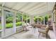 Bright sunroom with wicker seating, neutral cushions, and views of the lush greenery outside at 2516 Cherry Hill Ln, Atlanta, GA 30360