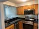 Well-lit kitchen equipped with modern stainless steel appliances, granite countertops, and wooden cabinetry at 2855 Peachtree Ne Rd # 106, Atlanta, GA 30305