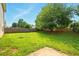 Spacious, grassy backyard with mature trees, a wooden fence and concrete patio at 3731 Laramie Rd, Ellenwood, GA 30294