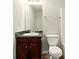 Bathroom featuring wood cabinets, dark countertops, toilet, and a large mirror at 3731 Laramie Rd, Ellenwood, GA 30294