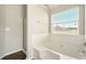 Bright bathroom with a tub and shower featuring a window, plus modern fixtures at 3731 Laramie Rd, Ellenwood, GA 30294