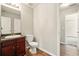 Bathroom with wood cabinets, dark countertops, toilet, and a view into the hallway at 3731 Laramie Rd, Ellenwood, GA 30294