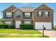 Charming two-story brick home featuring a well-kept lawn and attached two-car garage at 3731 Laramie Rd, Ellenwood, GA 30294