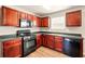 Kitchen featuring cherry cabinets, laminate floors, and modern appliances at 3731 Laramie Rd, Ellenwood, GA 30294