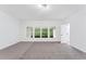 Bright bedroom with plush carpet, three windows, and an ensuite bathroom at 5705 Registry Oaks Se Ln, Mableton, GA 30126