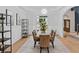 Bright dining room features a modern light fixture, a wood dining table, and six upholstered chairs at 5705 Registry Oaks Se Ln, Mableton, GA 30126