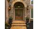 Elegant stone entrance featuring a beautifully crafted wood door and decorative sconces at 5705 Registry Oaks Se Ln, Mableton, GA 30126