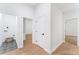 Hallway with hardwood floors, white doors, and a laundry room at 5705 Registry Oaks Se Ln, Mableton, GA 30126