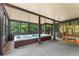 Enclosed sunroom area featuring a large hot tub and sauna at 5705 Registry Oaks Se Ln, Mableton, GA 30126