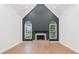 Spacious living room featuring hardwood floors, modern fireplace, and arched windows overlooking lush greenery at 5705 Registry Oaks Se Ln, Mableton, GA 30126