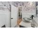 Charming powder room featuring a vessel sink, decorative wallpaper, and modern fixtures at 5705 Registry Oaks Se Ln, Mableton, GA 30126