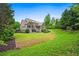 Expansive backyard view of home featuring a screened-in porch, green lawn, and landscaped perimeter at 771 Tate Overlook, Marietta, GA 30064