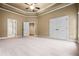 Spacious bedroom featuring neutral carpeting, a tray ceiling, and multiple closets at 771 Tate Overlook, Marietta, GA 30064