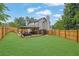 Large, fenced backyard with green grass, outdoor patio with seating, dining, and grilling areas at 1701 English Ivey Nw Ln, Kennesaw, GA 30144
