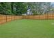 A large, well-maintained backyard features lush green grass and a tall wooden fence for privacy at 1701 English Ivey Nw Ln, Kennesaw, GA 30144