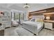 Stylish Primary bedroom with wood accent wall, tray ceiling, and large windows at 1701 English Ivey Nw Ln, Kennesaw, GA 30144