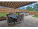 Outdoor covered patio boasts a built-in kitchen, stone flooring, and a privacy fence with manicured landscaping at 1701 English Ivey Nw Ln, Kennesaw, GA 30144