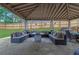 Spacious covered patio with stone floor, outdoor seating, dining area, grill, and a fenced backyard at 1701 English Ivey Nw Ln, Kennesaw, GA 30144