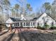 Rear exterior of home featuring a brick patio, pergola, and wall of windows at 5090 Eubanks Rd, Woodstock, GA 30188