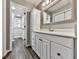 Bright bathroom featuring wood flooring, decorative mirror, white vanity, and recessed lights at 5090 Eubanks Rd, Woodstock, GA 30188