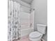 Bathroom featuring a shower-tub combo, floral shower curtain, and ceramic tile flooring at 5090 Eubanks Rd, Woodstock, GA 30188