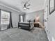 Cozy bedroom with neutral walls, plush carpet, ceiling fan, and a view of the outdoors from the window at 5090 Eubanks Rd, Woodstock, GA 30188
