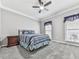 Bedroom features a ceiling fan, large windows, neutral paint, and carpet at 5090 Eubanks Rd, Woodstock, GA 30188