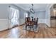 Formal dining room with wainscoting, hardwood floors, and stylish lighting with a view to the exterior at 5090 Eubanks Rd, Woodstock, GA 30188