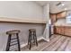 Kitchenette with wooden bar stools, a wooden breakfast bar, and wooden cabinets with a stainless steel refrigerator at 5090 Eubanks Rd, Woodstock, GA 30188