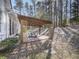 Covered patio with wood pergola and stepping stones to the lawn at 5090 Eubanks Rd, Woodstock, GA 30188