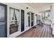 Inviting covered porch with 'Welcome HOME' decor, wooden flooring, and stylish black accents at 5090 Eubanks Rd, Woodstock, GA 30188
