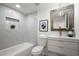 Bright bathroom featuring tub, toilet, and vanity with marble-style tile and decor at 569 Oakside Sw Dr, Atlanta, GA 30331