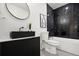 Modern bathroom featuring a black vanity, bathtub with black marble-look tile surround at 569 Oakside Sw Dr, Atlanta, GA 30331