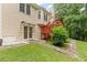 Landscaped backyard with lush green grass, a small red deck, and a quaint patio area at 775 Tribble Cove Dr, Lawrenceville, GA 30045