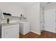 This laundry room has modern washer and dryer, a shelving unit, and vinyl flooring at 775 Tribble Cove Dr, Lawrenceville, GA 30045
