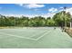 Professional-grade tennis court with excellent lighting, surrounded by mature trees and greenery at 775 Tribble Cove Dr, Lawrenceville, GA 30045