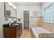 Bathroom with vanity, granite counters, tub with decorative tile surround and view of closet at 176 Ormond Se St, Atlanta, GA 30315